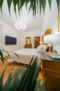 a bedroom with a large bed and a chandelier at Domus Emma in Cantalupo in Sabina