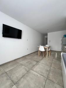 a living room with a table and a tv on the wall at FINCA NOVA Apartment 7 in Balcarce