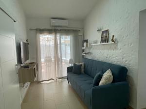 a living room with a blue couch in front of a window at Tartanas Granca in Playa del Ingles +25 photos