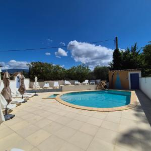 Una piscina en un patio con sillas y un cielo azul. en Résidence Les Salettes, en Mormoiron
