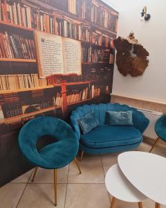 a living room with a blue couch and bookshelves at Hotel Alba Chiara Sant'Andrea Salento in SantʼAndrea