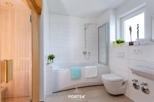 a bathroom with a tub and a toilet and a sink at Hoppetosse in Olpenitz