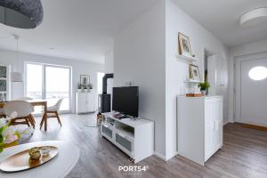 a white living room with a tv and a table at Hoppetosse in Olpenitz +21 photos