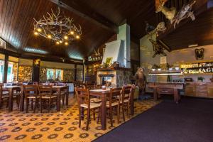 un ristorante con tavoli e sedie in legno e un camino di Brunarica Bled Zatrnik Pokljuka a Bled