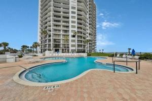 a swimming pool in front of a tall building at Beachfront 3 Bed, 3 Bath Condo, Balcony & Pool in Daytona Beach Shores