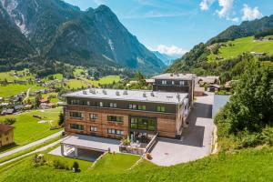 a house on a hill with mountains in the background at Haus Gaues in Dalaas