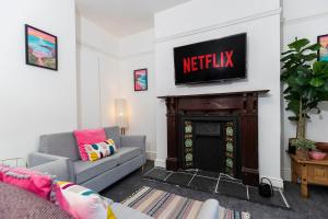 a living room with a television on top of a fireplace at 4 BEDS, 4 BATHS home, central Darlington in Darlington