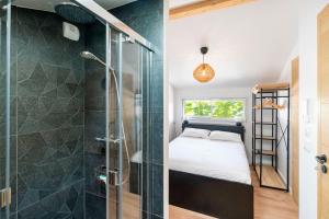 a bathroom with a shower and a bed in a room at Maison de vacances Des Tucs Dou in Seignosse