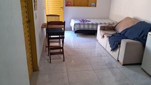 a living room with a couch and a table and chairs at Chalé Azul Aurora in Manhã