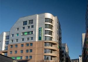 a tall building with a green sign on it at Burley Road in City Centre - Leeds in Leeds +12 photos