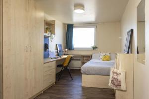 a bedroom with a bed and a desk with a computer at Burley Road in City Centre - Leeds in Leeds