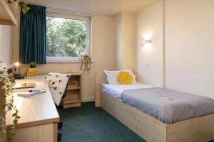 a bedroom with a bed and a desk and a window at Burley Road in City Centre - Leeds in Leeds