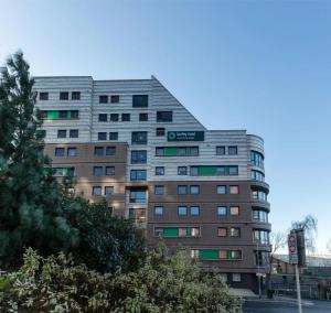a tall building with a tree in front of it at Burley Road in City Centre - Leeds in Leeds