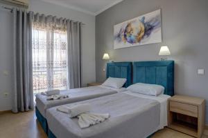 a bedroom with two beds and a window at MAKIS STUDIOS in Roda +39 photos