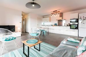 una sala de estar con un sofá y una mesa en Appartement Lumineux avec Terrasse, en Seignosse