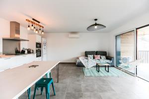 Una cocina y una sala de estar con mesa y sillas. en Appartement Lumineux avec Terrasse, en Seignosse