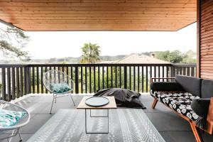 un patio con sofá y sillas en una terraza en Appartement Lumineux avec Terrasse, en Seignosse 2 fotos más