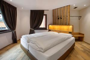 a bedroom with a large bed with a wooden headboard at Borch Chalet Livigno in Livigno