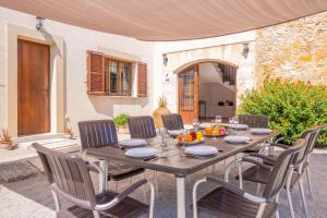 a wooden table with chairs and a tableasteryasteryasteryasteryasteryasteryasteryastery at Sa Corterada in El Port de la Selva