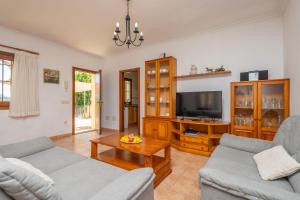 a living room with two couches and a tv at Sa Corterada in El Port de la Selva