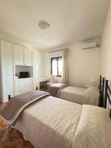 a bedroom with two beds and a desk and a window at Il giardino del Sole in Florinas
