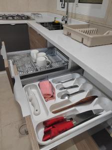 a kitchen with an open drawer filled with utensils at وادي العقيق203 in Al Madinah