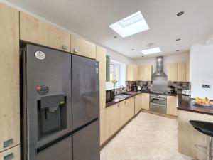 a kitchen with a stainless steel refrigerator in at Bassetts House - Contractor ready! in Farnborough