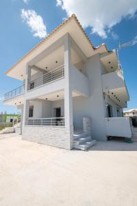 a white house with a balcony on a beach at Zante Escape Suites by "elite" in Laganas
