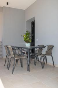 a black dining room table with chairs and a potted plant at Zante Escape Suites by "elite" in Laganas