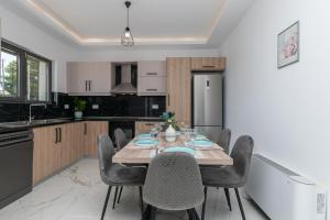 a kitchen with a wooden table and chairs in a room at Zante Escape Suites by "elite" in Laganas