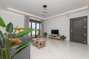 a living room with a couch and a tv at Zante Escape Suites by "elite" in Laganas