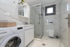 a bathroom with a washing machine and a shower at Zante Escape Suites by "elite" in Laganas +13 photos
