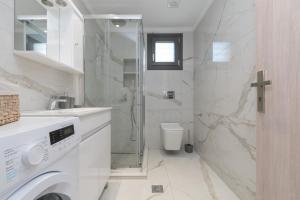 ein Badezimmer mit Dusche und Waschmaschine in der Unterkunft Zante Escape Suites by "elite" in Laganas + 13 Fotos