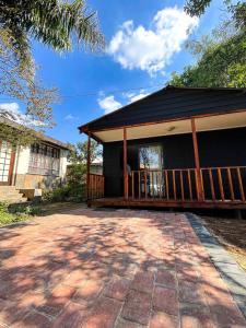 a black house with a porch and a patio at The Shed - Capital Park in Pretoria
