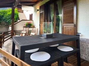 a black table with white plates on a patio at La CRI Bed & Breakfast in Giustino