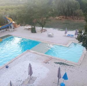 an overhead view of a swimming pool with umbrellas and a playground at B&B RosAngelo in Mirabella Imbaccari
