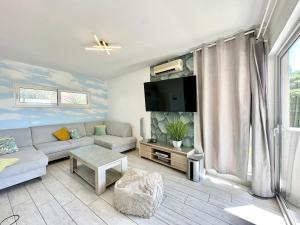 a living room with a couch and a tv at Apartments Villa A - Heating Pool in Trogir