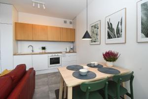 a kitchen and living room with a table and a couch at Apartament MALIN in Mrągowo