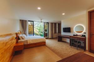 a bedroom with a bed and a desk and a television at Aire Dharavandhoo in Dharavandhoo +75 photos