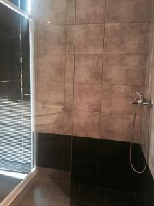 W łazience znajduje się prysznic ze szklanymi drzwiami. w obiekcie Feevos w Pireusie