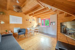 a kitchen and living room with a table and chairs at Kolorowe Domki in Pobierowo