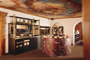 a kitchen with a table with aasteryasteryasteryasteryasteryasteryasteryasteryastery at Burg Hotel Lech am Arlberg in Lech am Arlberg +110 photos