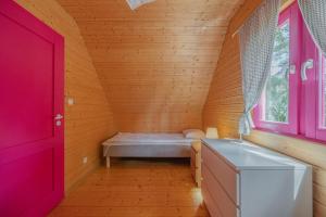 a room with a bed in a wooden room at Kolorowe Domki in Pobierowo