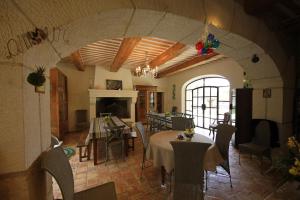 a dining room with tables and chairs and a fireplace at Mas Loisonville in Grillon