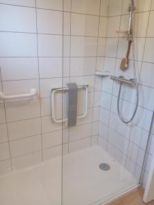 une douche avec une porte vitrée dans une salle de bain dans l'établissement Chez Marinette, à Saint-Jean-Saint-Nicolas