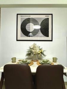 a dining room table with two chairs and a picture on the wall at Philhaus Staycation 2025 in Manila