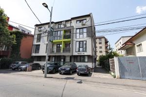 a white building with cars parked in front of it at Lacul Morii Cozy Stay in Bucharest