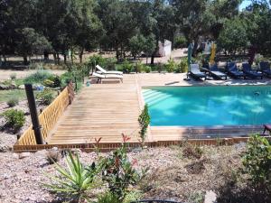 a wooden deck next to a swimming pool with chairs at Chalet Conca in Conca +20 photos