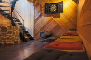 a room with a staircase and a dartboard in a cabin at Gîte La Grenadine in Saint-Firmin