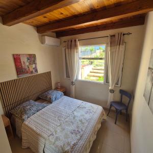 un dormitorio con una cama y una ventana en Résidence Les Salettes, en Mormoiron